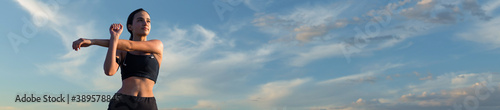 фотографія Female posing in sportswear on sky background