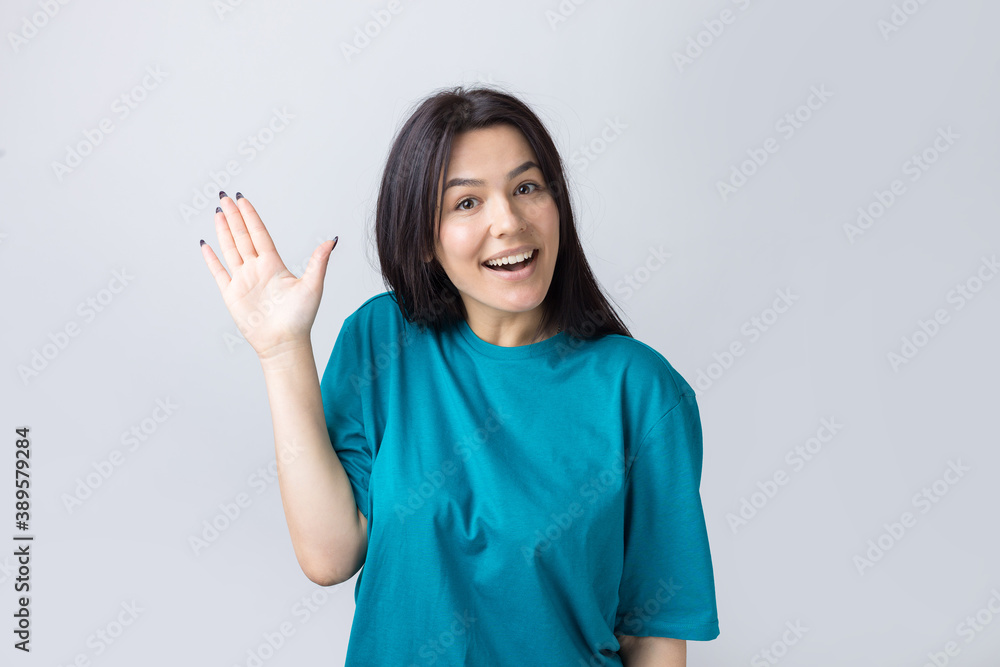 Smiling woman raised her hand palm up and forward like waving. Smiling woman raised her hand palm up and forward like waving.
