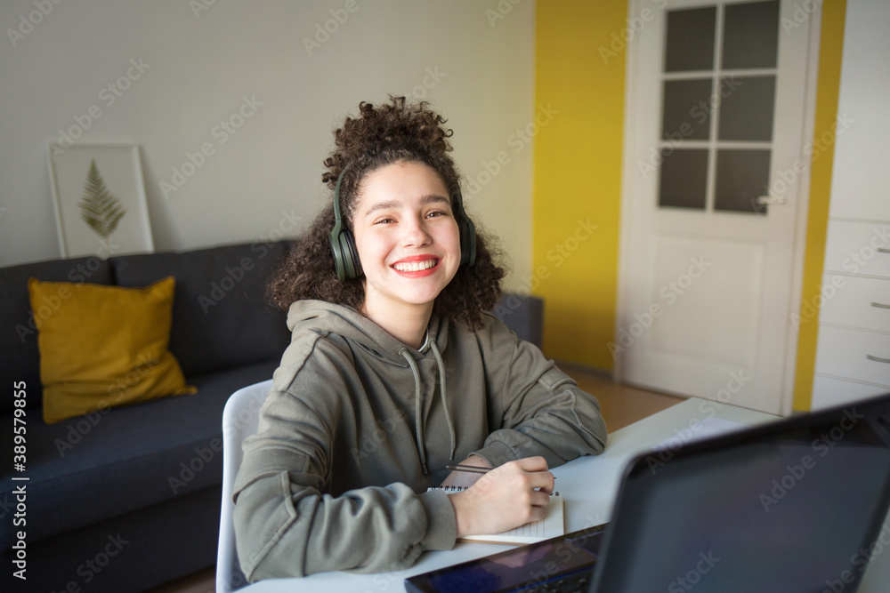 happy mixed rase girl sits at computer screen laptop. student talks over Internet. Video Conference or e-learning at home happy mixed rase girl sits at computer screen laptop. student talks over Internet. Video Conference or e-learning at home