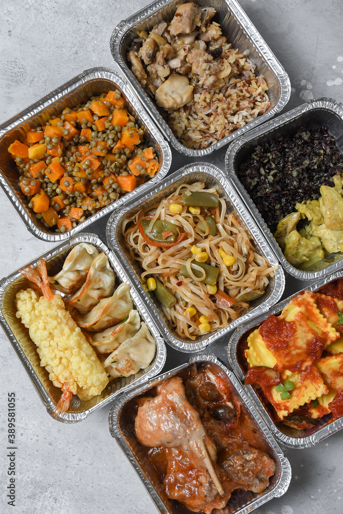 Different aluminium lunch box with with takeout coronavirus food.  Food delivery covid-19 takeaway 