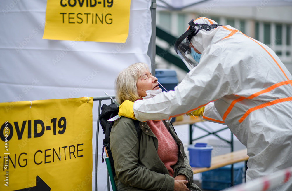 Fototapeta premium Senior woman in covid-19 testing center outdoors on street, coronavirus and swab taking concept.