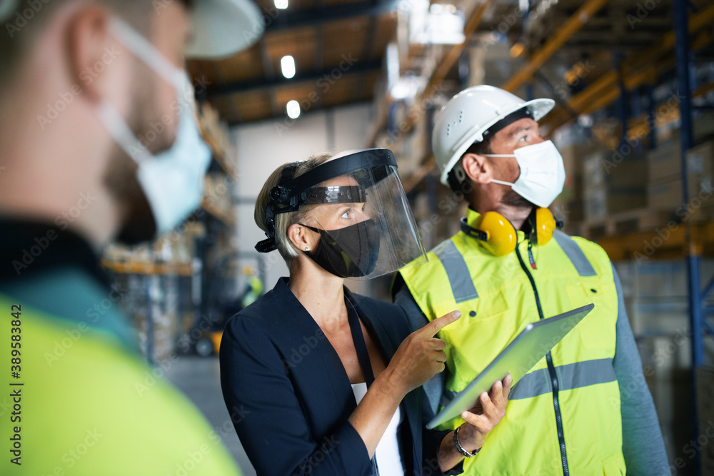 Group of workers with manager working indoors in warehouse, coronavirus concept. Group of workers with manager working indoors in warehouse, coronavirus concept.
