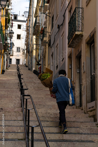 man climbs some stairs with a bouquet of flowers