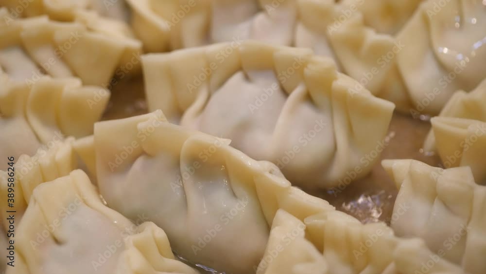 フライパンに並べた手作り餃子に水を入れて焼いてる動画。 フライパンに並べた手作り餃子に水を入れて焼いてる動画。