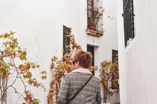 Woman walking around beautiful Córdoba streets, white walls and flores.