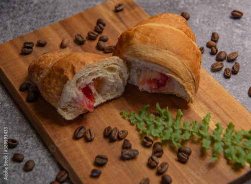 croissant with strawberry jam and coffee beans
