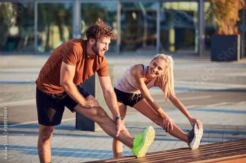Fototapeta Naklejka Na Ścianę i Meble -  Young adult sporty couple working out outdoors in urban surroundings.