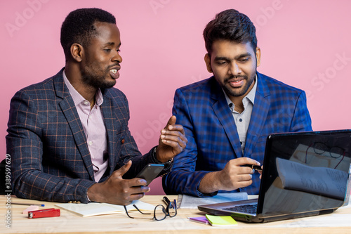 Two businessmen speaking and working at the office photo