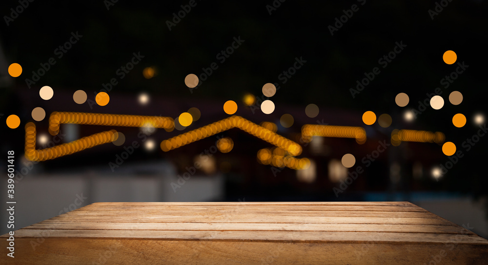 Empty wood table top on blurred light gold bokeh of cafe restaurant bar on dark background Empty wood table top on blurred light gold bokeh of cafe restaurant bar on dark background