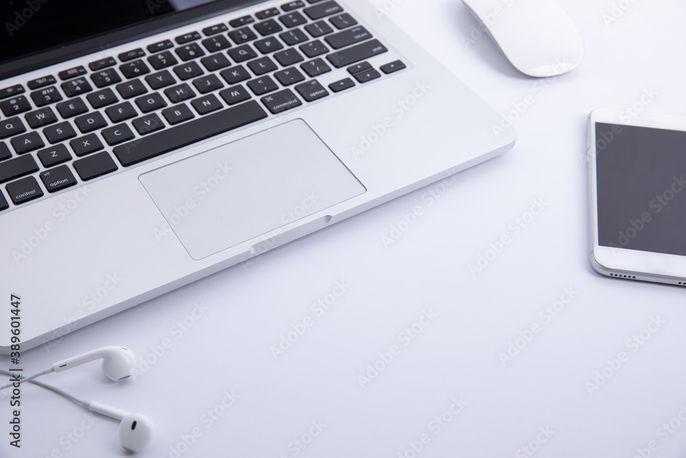new modern laptop keyboard with computer mouse and earphones with smartphone isolated on white background, close view . High quality photo new modern laptop keyboard with computer mouse and earphones with smartphone isolated on white background, close view . High quality photo