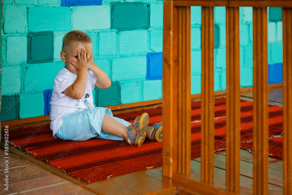 the child is shy and hides his face with his hands the child is shy and hides his face with his hands