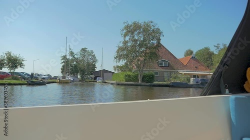 Sailing past a Monumental Farmbuilding with a boat in the summer. photo