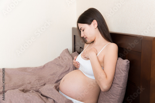 Close Up of pregnant women having painful feelings in breast. Woman checking her breast for cancer photo