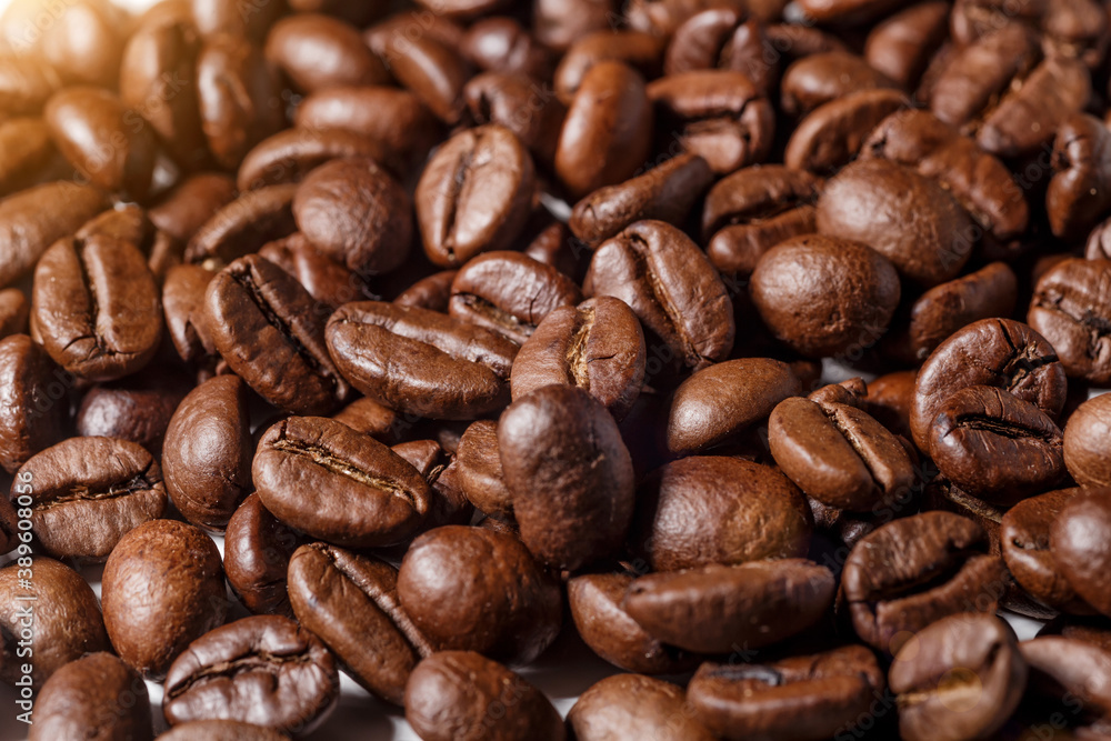 Freshly roasted coffee beans background.Dark roasted coffee beans with scoop on wooden background. Freshly roasted coffee beans background.Dark roasted coffee beans with scoop on wooden background.