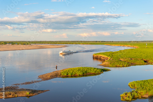 River movement of a passenger ship. Evening summer river landscape © Niko