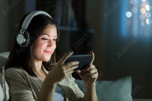 Relaxed woman watching video in the night at home photo