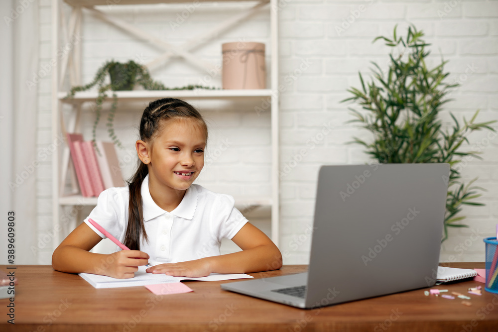 happy little child girl using laptop for studying online learning system. online lesson at home happy little child girl using laptop for studying online learning system. online lesson at home