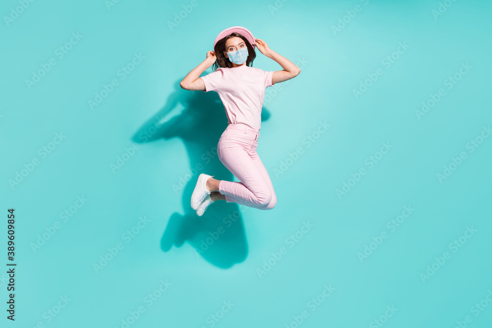 Full length photo of girl jumping having fun wear facial respirator isolated bright turquoise color background