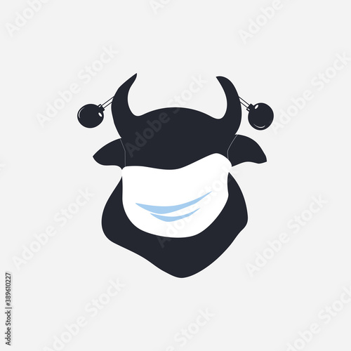 New Year. Black silhouette of a bull in a medical mask and with Christmas balls on its horns is a symbol of 2021.
