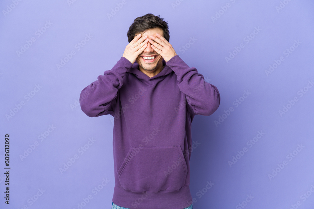 Young cool man covers eyes with hands, smiles broadly waiting for a surprise. Young cool man covers eyes with hands, smiles broadly waiting for a surprise.