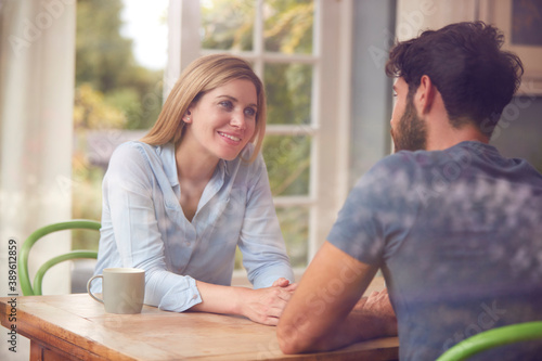 Couple Meeting For Date In Coffee Shop Viewed Through Window