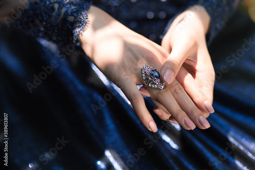 Fotografie Close-up of beautiful bijou female ring with blue stone on the woman hand