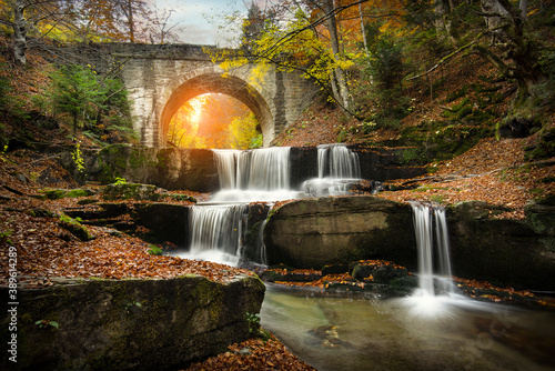 Autumn waterfalls near Sitovo, Plovdiv, Bulgaria. Beautiful cascades of water with fallen yellow leaves under the bridge. Sitovski waterfall