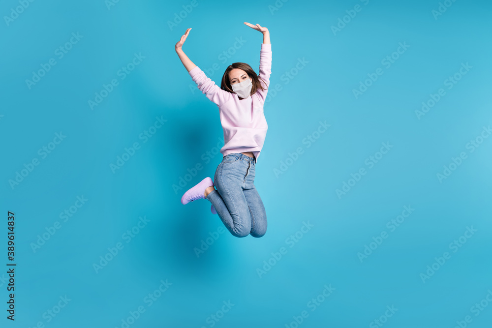 Full body photo of crazy excited girl jump raise hands wear white face mask isolated over blue pastel color background