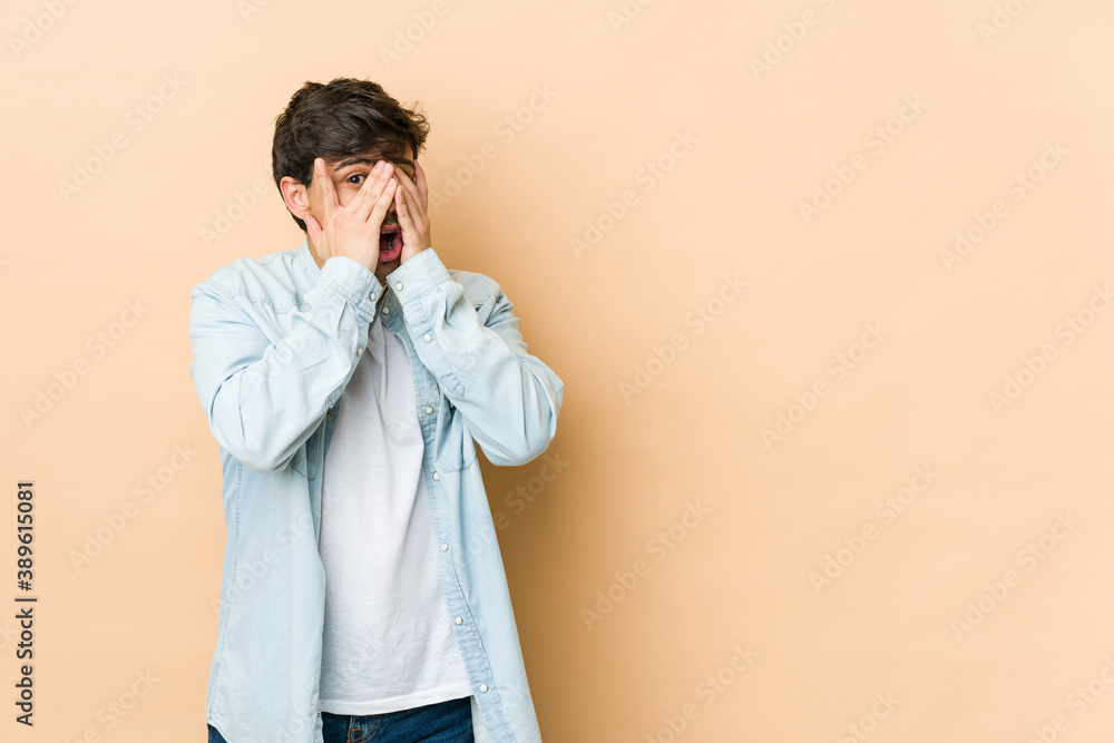 Young cool man blink through fingers frightened and nervous. Young cool man blink through fingers frightened and nervous.