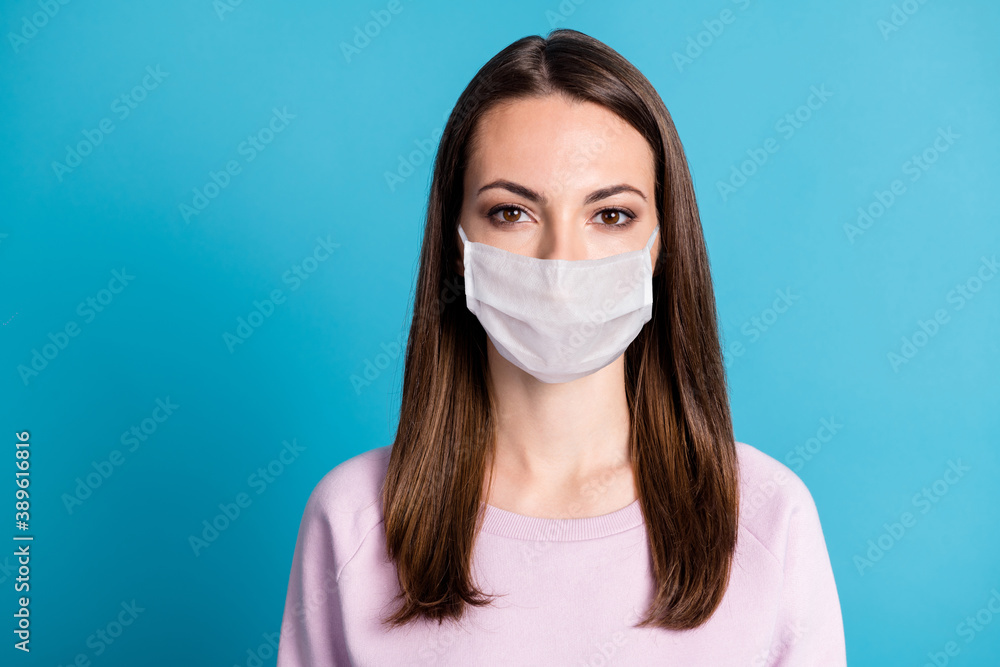 Close-up portrait of girl wearing white face mask isolated over bright vivid shine vibrant blue color background Close-up portrait of girl wearing white face mask isolated over bright vivid shine vibrant blue color background