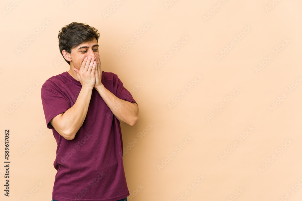 Young cool man laughing about something, covering mouth with hands. Young cool man laughing about something, covering mouth with hands.