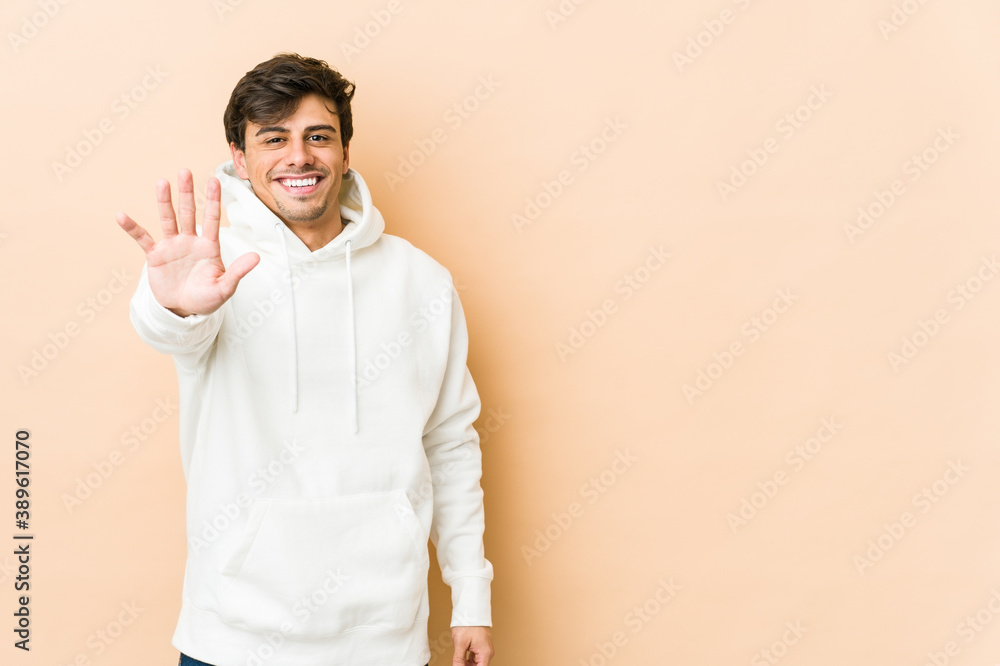 Young cool man smiling cheerful showing number five with fingers. Young cool man smiling cheerful showing number five with fingers.