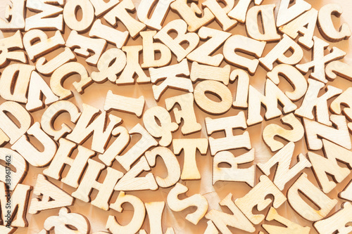 Wooden English letters are scattered over the light surface. Concept for alphabet, writing and journalism, storytelling, learning.