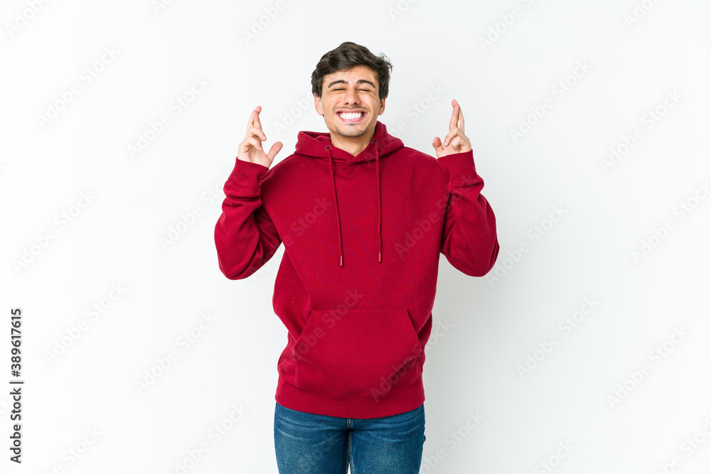 Young cool man crossing fingers for having luck Young cool man crossing fingers for having luck
