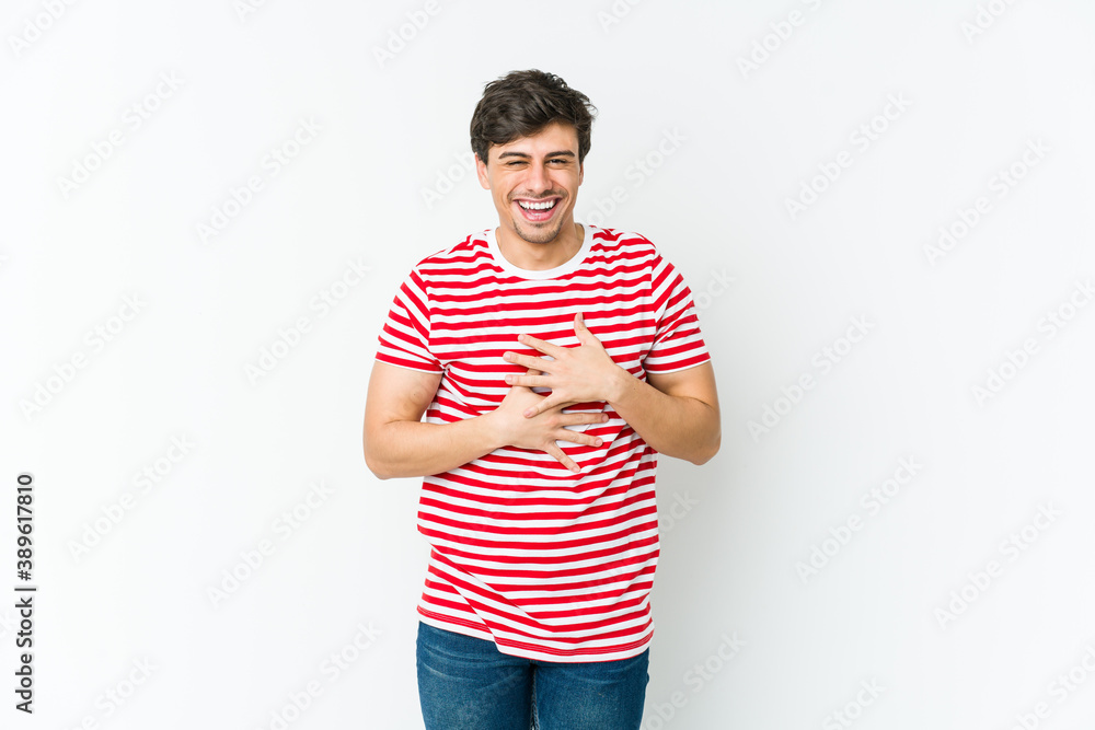 Young cool man laughs happily and has fun keeping hands on stomach. Young cool man laughs happily and has fun keeping hands on stomach.