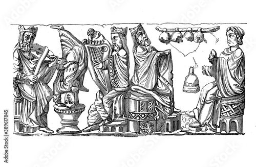 Medieval musical performance: noble figures playing string instruments and bells, and a jester upside-down, bas-relief of 11th century