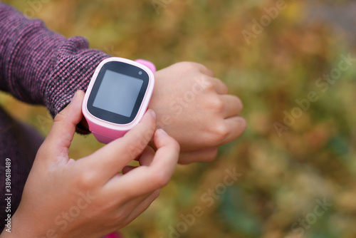 Smart watch on the child's hand. Girl includes smart watches finger.