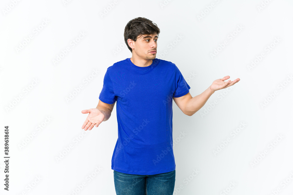 Young cool man confused and doubtful shrugging shoulders to hold a copy space. Young cool man confused and doubtful shrugging shoulders to hold a copy space.