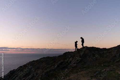 Silhouette of couple on mountain during sunrise.