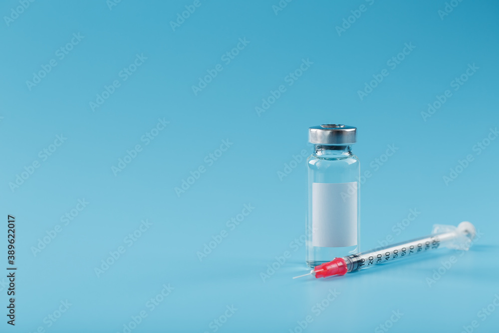 Syringe and ampoule with a vaccine against viruses and diseases on a blue background. Syringe and ampoule with a vaccine against viruses and diseases on a blue background.