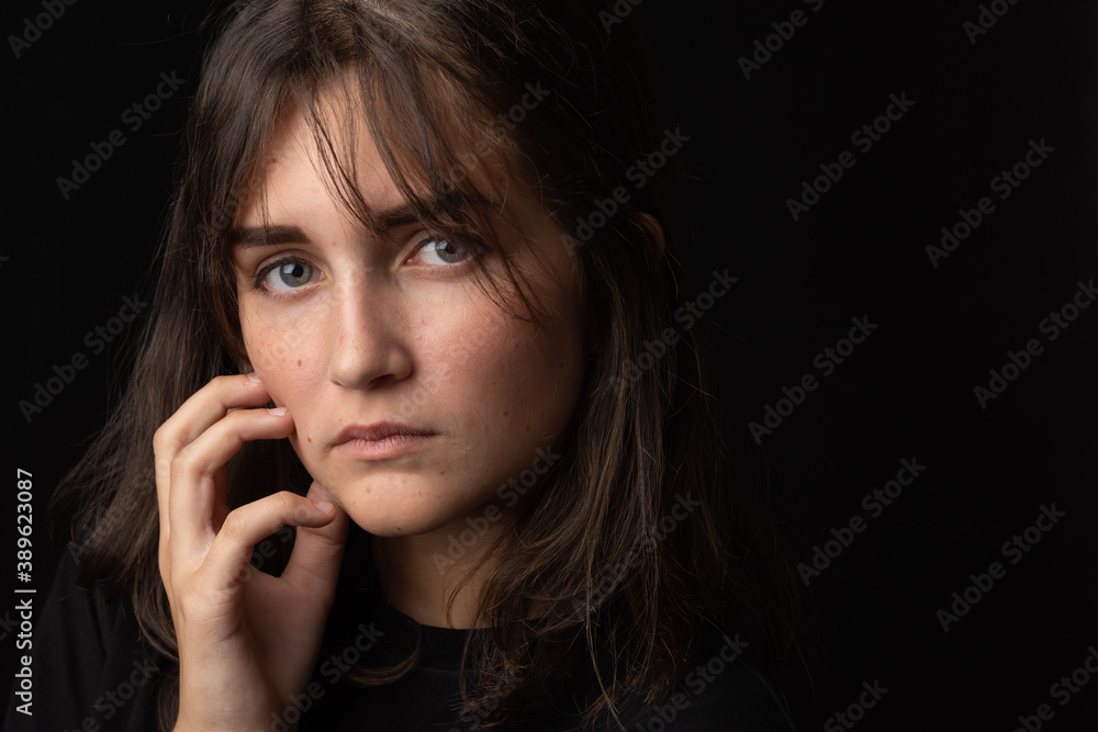 Portrait of a beautiful girl with a thoughtful look on a black background Portrait of a beautiful girl with a thoughtful look on a black background