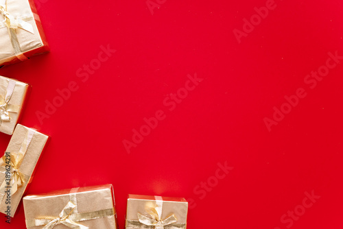 Red Christmas or new year's background, plain composition of golden Christmas gifts. Flatlay, empty space for greeting text.christmas concept.