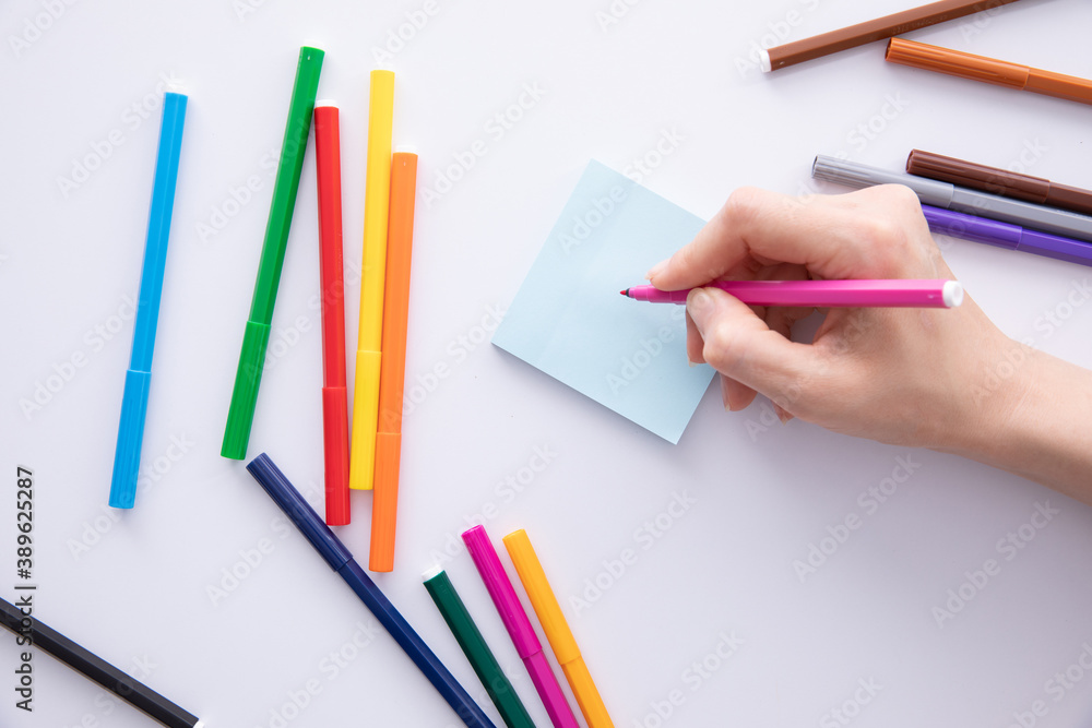 female hand writing with felt-tip pen over paper note on table, close view. High quality photo female hand writing with felt-tip pen over paper note on table, close view. High quality photo