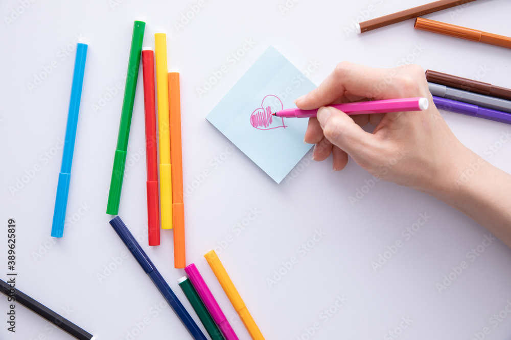 female hand writing with felt-tip pen over paper note on table, close view. High quality photo female hand writing with felt-tip pen over paper note on table, close view. High quality photo