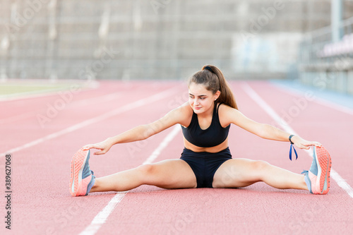 Fit female teenager runner stretching before a race - Healthy lifestyle concept
