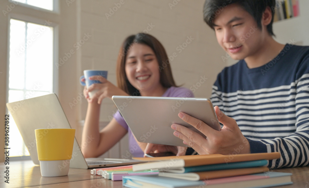 Young men and young women were taking a video conference on their tablets, They were reading exam preparation books. Young men and young women were taking a video conference on their tablets, They were reading exam preparation books.