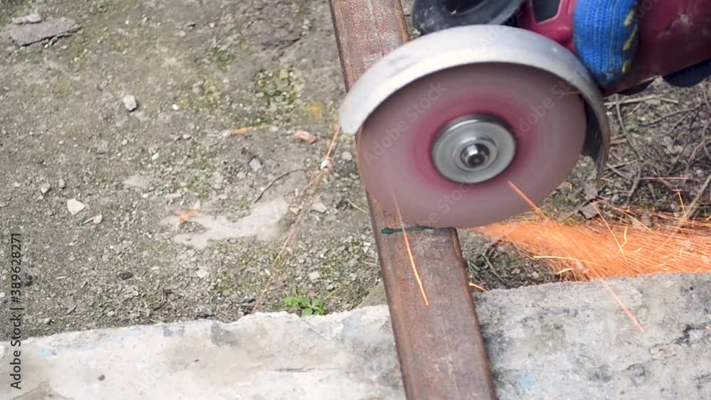 Cutting metal pipes with a grinder in an open space. using a power tool