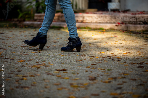 Closeup of - Young female walking on the sidewalk at fall