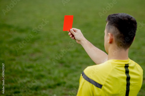 Referee showing a red card to a displeased football or soccer player while gaming. Concept of sport, rules violation, controversial issues, obstacles overcoming.