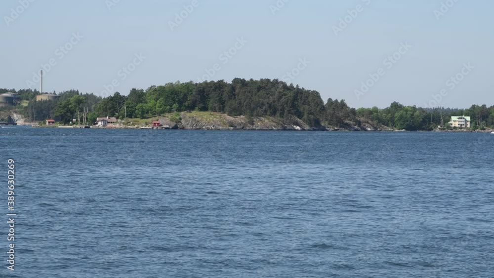 A commuting boat passing the island Karlsudd in Stockholm a sunny summer day A commuting boat passing the island Karlsudd in Stockholm a sunny summer day